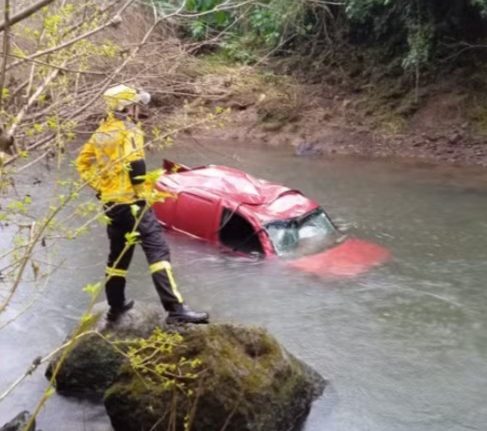Mulher morreu após o veículo que conduzia sair da pista e cair em um rio - Foto Redes Sociais Reprodução e Corpo de Bombeiros Divulgação