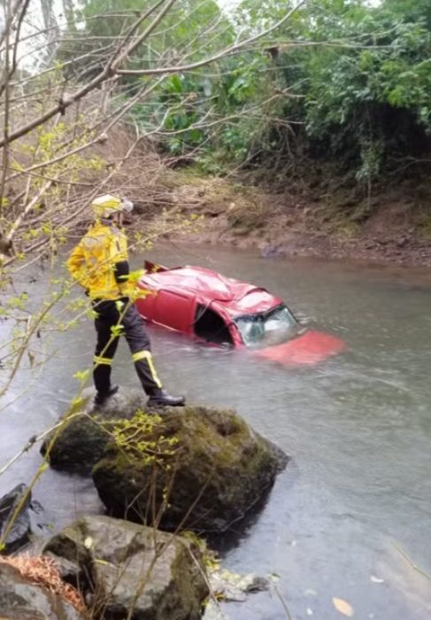 Mulher morreu após o veículo que conduzia sair da pista e cair em um rio - Foto Redes Sociais Reprodução e Corpo de Bombeiros Divulgação