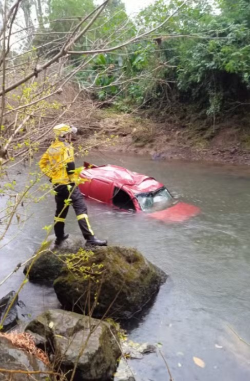 Mulher morreu após o veículo que conduzia sair da pista e cair em um rio - Foto Redes Sociais Reprodução e Corpo de Bombeiros Divulgação