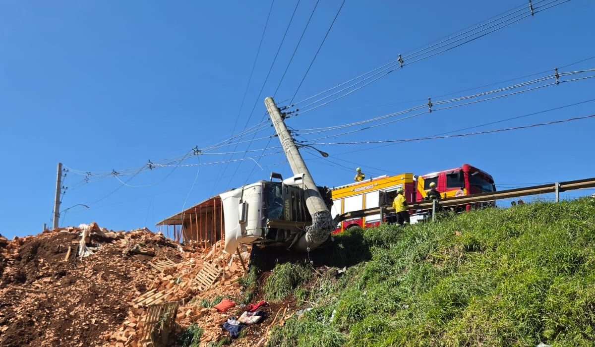 Carreta carregada de tijolos capota e bate no guard rail e em um poste de energia em Chapecó - Fotos Corpo de Bombeiros